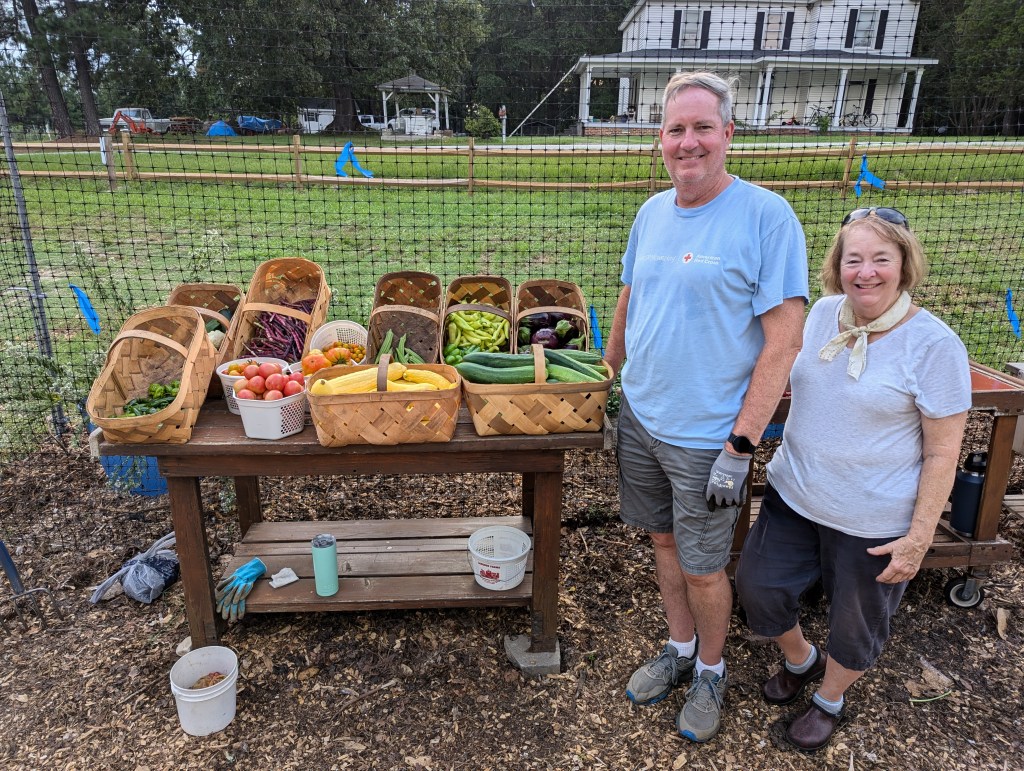 Gardeners next to produce in baskets